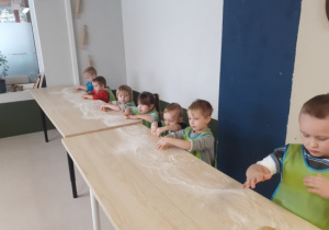 Dzieci ugniatają ciasto.