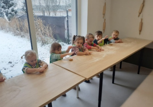 Dzieci ugniatają ciasto.