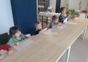 Dzieci jedzą pizzę.