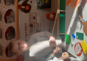 Chłopiec wykonuje filcowego jeżyka.