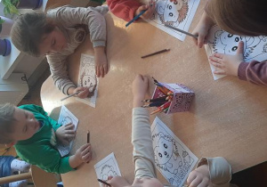 Dzieci kolorują jeżyki.