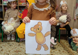 Dziewczynka wykleiła misia wg wzoru.