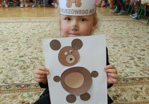 Dziewczynka wykleiła misia wg wzoru.