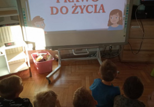 Dzieci oglądają prezentację dotyczącą praw dziecka.