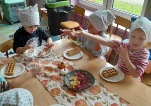 Dzieci uczestniczą w warsztatach kulinarnych.