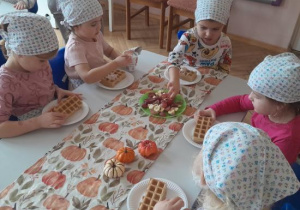 Dzieci uczestniczą w warsztatach kulinarnych.