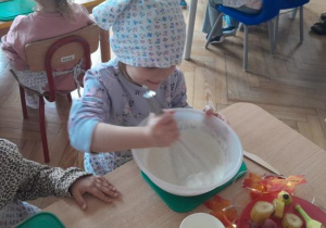 Dzieci uczestniczą w warsztatach kulinarnych.