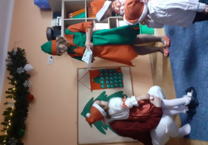 Dzieci i rodzice biorą udział w spotkaniu mikołajkowym.