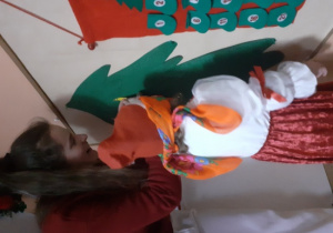 Dzieci i rodzice biorą udział w spotkaniu mikołajkowym.