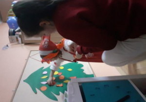 Dzieci i rodzice biorą udział w spotkaniu mikołajkowym.