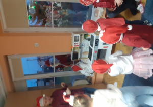 Dzieci i rodzice biorą udział w spotkaniu mikołajkowym.