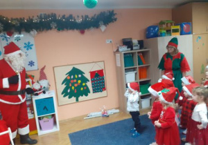 Dzieci i rodzice biorą udział w spotkaniu mikołajkowym.