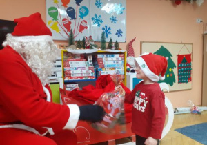 Dzieci i rodzice biorą udział w spotkaniu mikołajkowym.