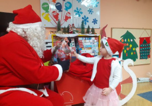 Dzieci i rodzice biorą udział w spotkaniu mikołajkowym.