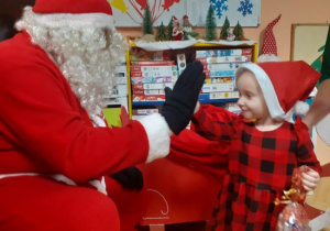 Dzieci i rodzice biorą udział w spotkaniu mikołajkowym.