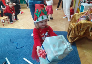 Dzieci i rodzice biorą udział w spotkaniu mikołajkowym.