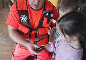Dzieci uczestniczą w spotkaniu z ratownikiem medycznym.