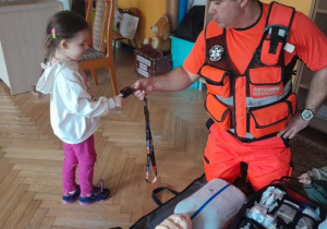 Dzieci uczestniczą w spotkaniu z ratownikiem medycznym.