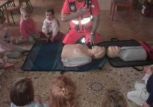 Dzieci uczestniczą w spotkaniu z ratownikiem medycznym.