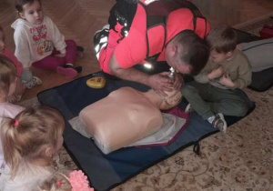 Dzieci uczestniczą w spotkaniu z ratownikiem medycznym.