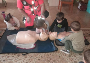 Dzieci uczestniczą w spotkaniu z ratownikiem medycznym.