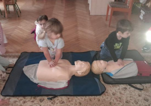 Dzieci uczestniczą w spotkaniu z ratownikiem medycznym.