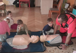 Dzieci uczestniczą w spotkaniu z ratownikiem medycznym.