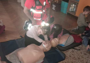 Dzieci uczestniczą w spotkaniu z ratownikiem medycznym.