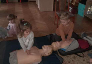 Dzieci uczestniczą w spotkaniu z ratownikiem medycznym.