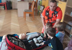 Dzieci uczestniczą w spotkaniu z ratownikiem medycznym.