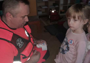 Dzieci uczestniczą w spotkaniu z ratownikiem medycznym.