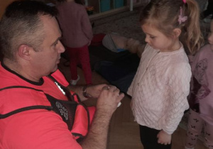 Dzieci uczestniczą w spotkaniu z ratownikiem medycznym.