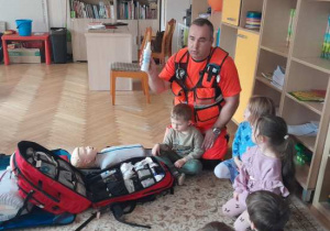 Dzieci uczestniczą w spotkaniu z ratownikiem medycznym.