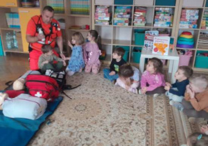 Dzieci uczestniczą w spotkaniu z ratownikiem medycznym.