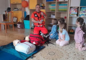 Dzieci uczestniczą w spotkaniu z ratownikiem medycznym.