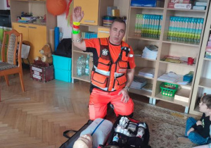 Dzieci uczestniczą w spotkaniu z ratownikiem medycznym.