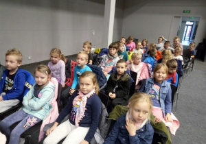 Dzieci siedzą na widowni w oczekiwaniu na przedstawienie