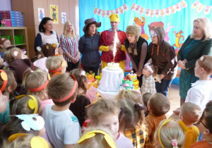 Zaproszeni goście i dzieci przy torcie urodzinowym